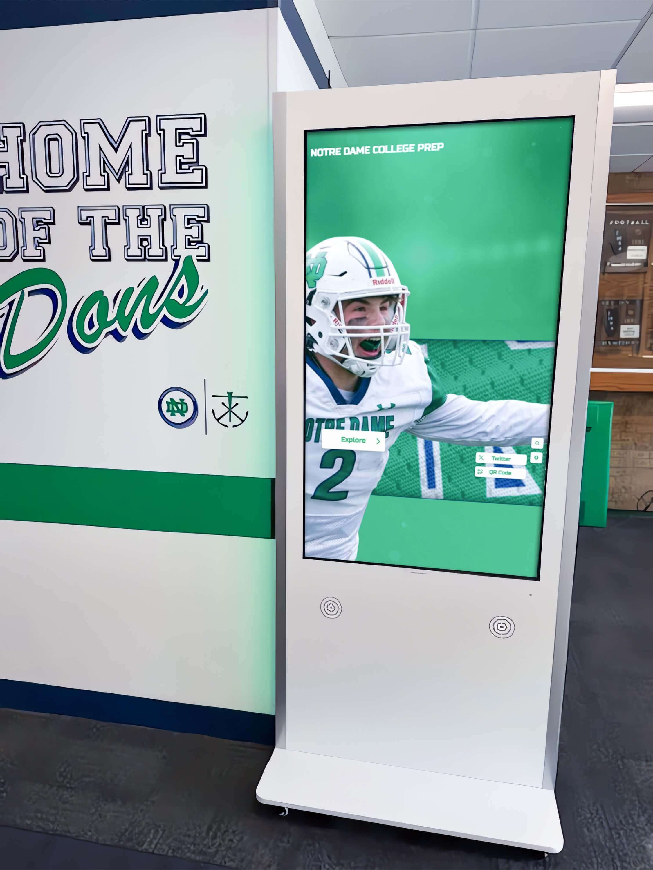 Interactive community recognition kiosk displaying program histories in institutional hallway